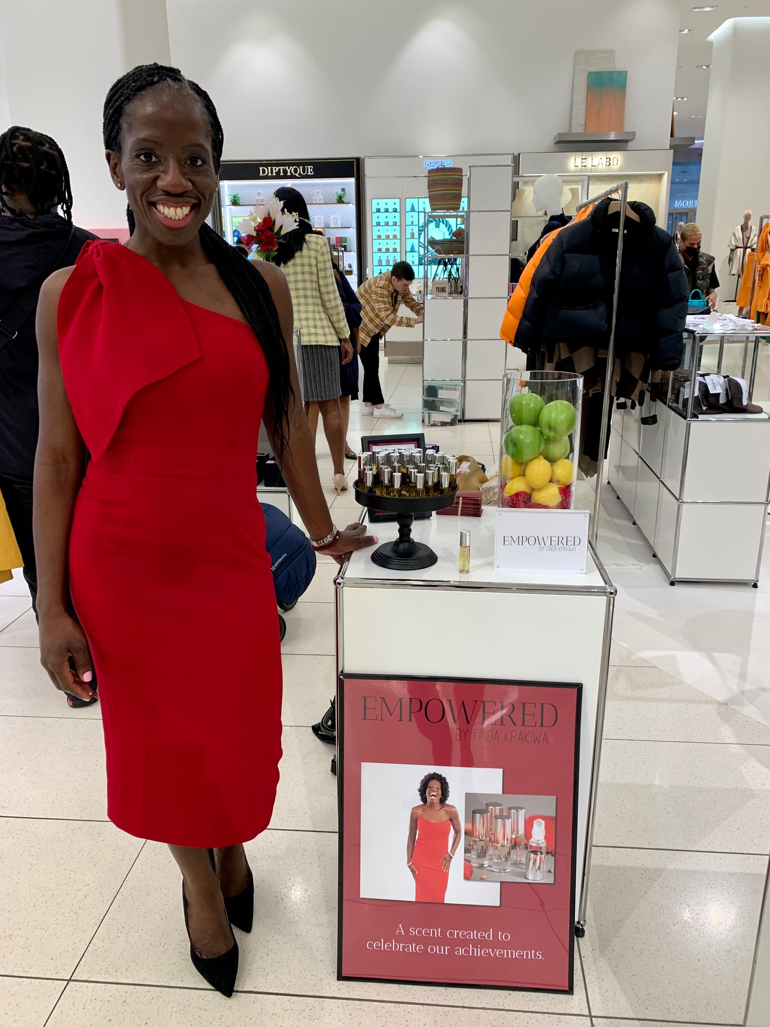 Finda Kpakiwa standing beside her fragrance display at Nordstrom's flagship store